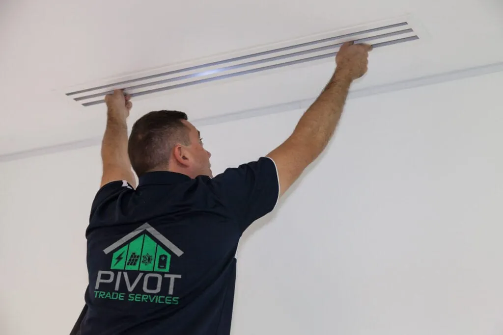 Pivot Trade Services technician fitting a linear ceiling vent for a ducted air conditioning system