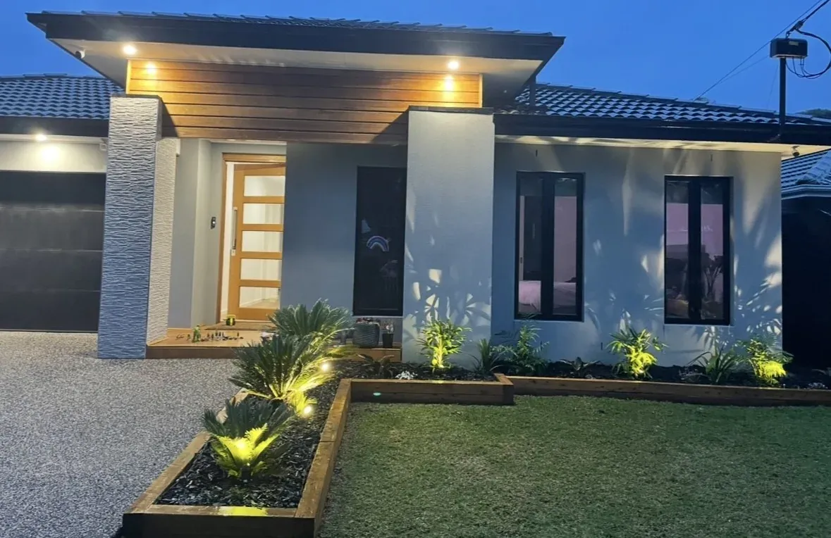 Contemporary Melbourne home lit at dusk with warm entry and landscape lighting