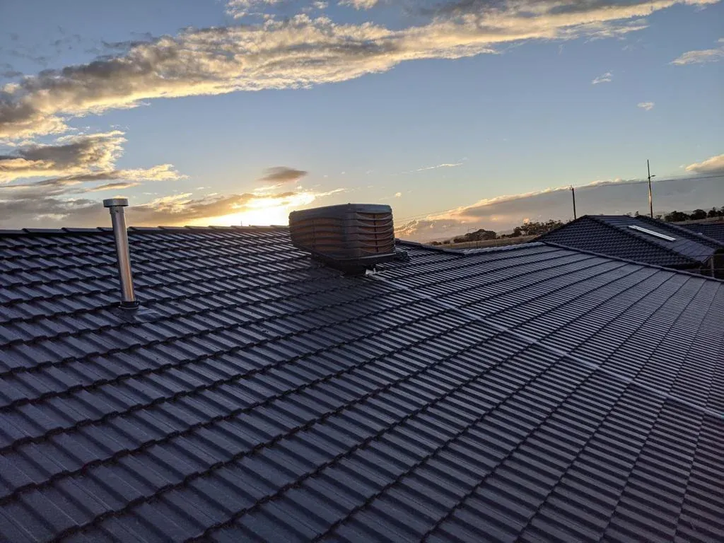 Solar panels on a dark tiled roof photographed at sunset