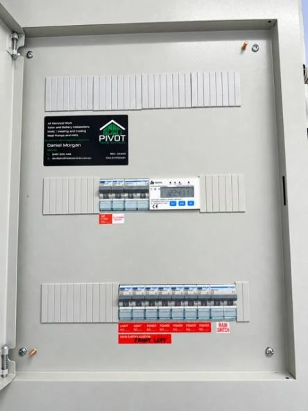 Open switchboard with every circuit labelled, safety switches fitted and a Pivot Trade Services compliance plate